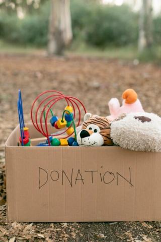 Cardboard box of toys set outside with "Donation" written on it